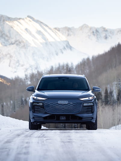 audi car driving on road in front of mountains
