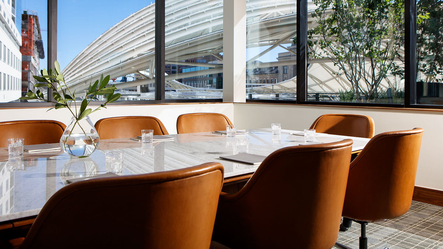 A conference table in a modern meeting room with large windows at Limelight Hotel in Denver, Colorado.