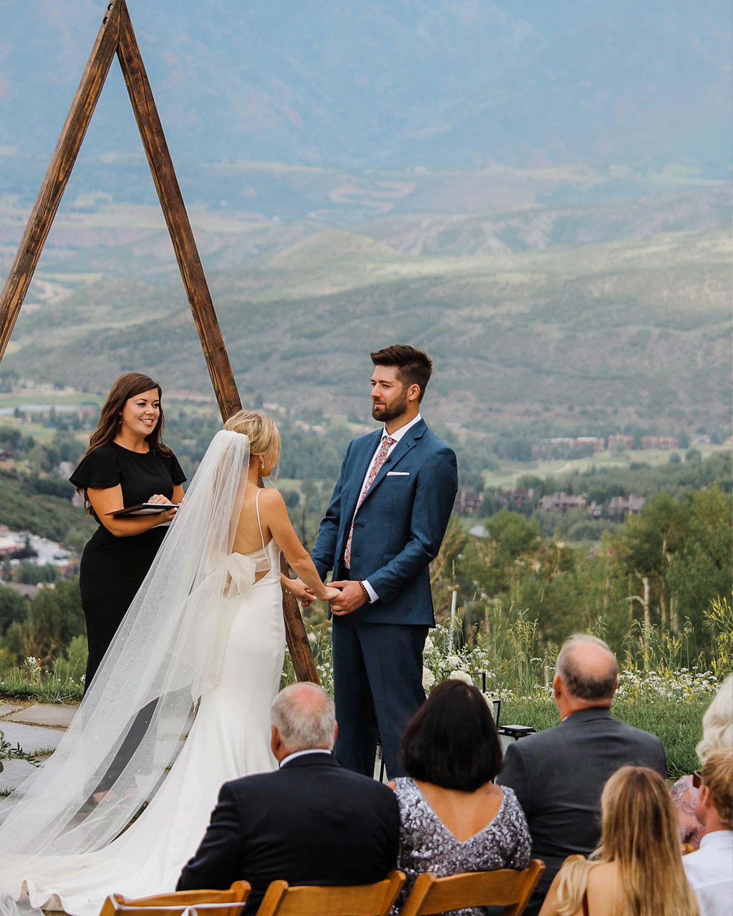 A bride and groom hold hands at their wedding located at Limelight Hotel in Snowmass, Colorado.