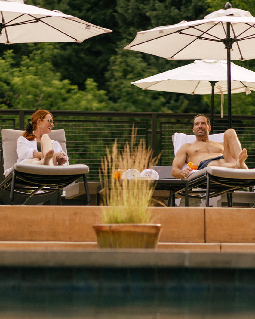 Couple lounging by the scenic pool at Limelight Ketchum