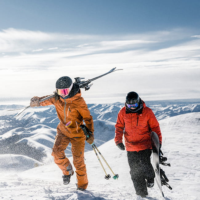 two skiers hiking up mountain