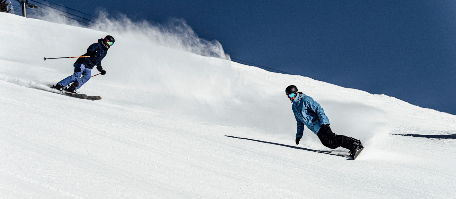 two skiers going down run